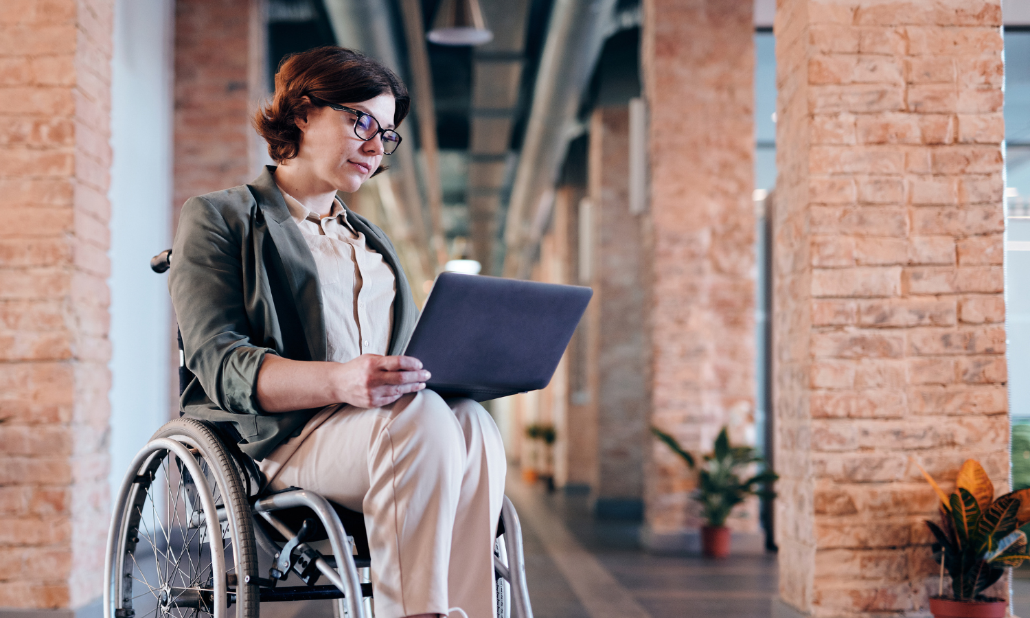 woman seated in wheelchair using a computer